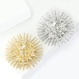 Broches soleil élégantes en or et argent avec relief de visage sur socles blancs