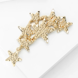 Close-up of golden rhinestone stars brooch with textured surface and star pendant