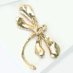 Detailed back view of golden dragonfly brooch showing safety pin and locking mechanism