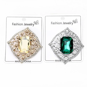 Detailed view of vintage crystal brooches in gold and silver with emerald and champagne stones