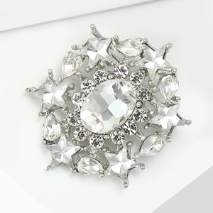 Macro view of starburst brooch featuring an oval crystal and silver geometric details
