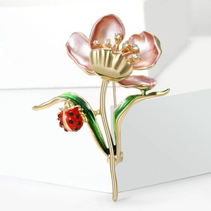 Vintage enamel lotus flower brooch with rhinestones and a ladybug on a gold stem