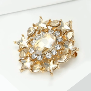 Macro shot of vintage style starburst brooch with champagne gemstones on a white stand