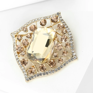 Macro detail of a baroque square brooch with champagne gems and white rhinestones