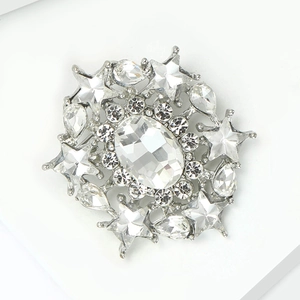 Detail view of silver alloy brooch with large oval crystal and star shaped rhinestones