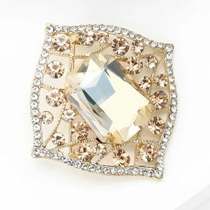Macro shot of vintage alloy brooch with amber glass gemstone and crystal accents