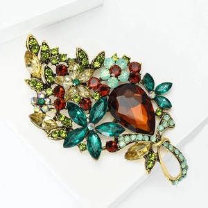 Detailed macro view of vintage alloy brooch with large amber crystal and colorful rhinestones