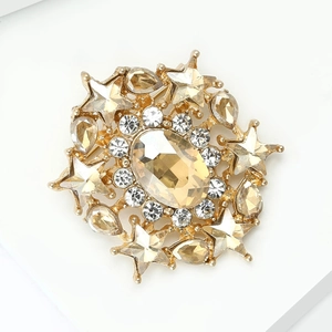 Detail of a luxury star-shaped gold brooch with champagne gemstone and crystals