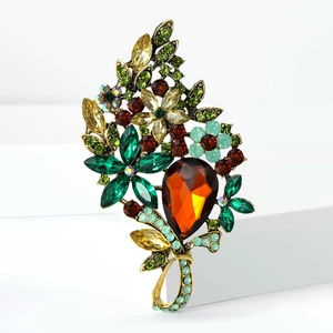 Macro detail of vintage floral alloy brooch with colorful crystals and large pear-cut stone