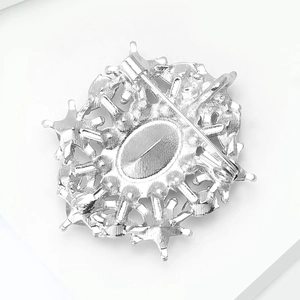 Close-up of the silver alloy brooch back showing the safety pin clasp and snowflake shape