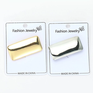 Detailed view of rectangular gold and silver polished alloy pins on jewelry display card