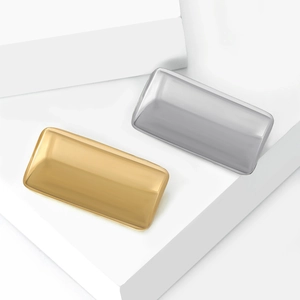 Detail view of rectangular minimalist metal trays in polished gold and silver finishes