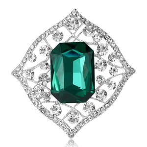 Vintage emerald-cut green glass brooch with silver rhinstone-encrusted lattice frame