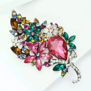 Detail view of large crystal flower brooch with vibrant pink teardrop gemstone