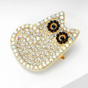Detailed view of cat brooch with sparkling rhinestones and gold plating on white surface