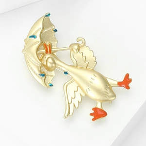 Dettaglio ravvicinato di una spilla a forma di anatra dorata con smalto arancione e gocce blu