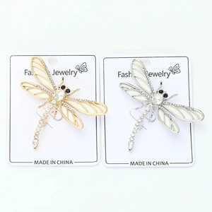 Vue macro détaillée de broches libellules or et argent avec strass et ailes en émail