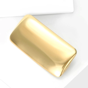 Macro shot of liquid metal gold rectangular brooch with polished finish on white pedestal