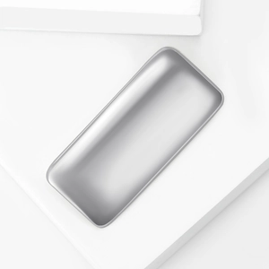Close-up of minimalist rectangular silver stainless steel storage tray on white stone
