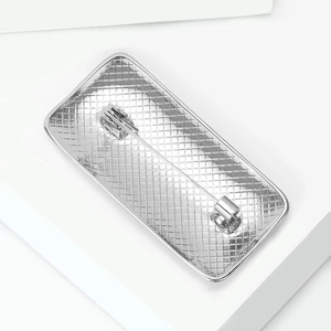 Detail view of the silver alloy brooch back with mesh texture and safety pin clasp