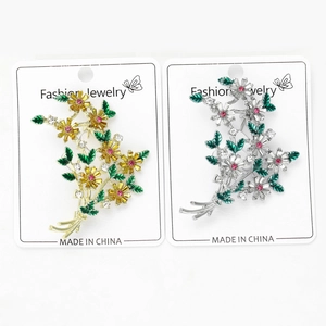 Vue détaillée de broches fleurs en émail coloré avec strass et accents dorés