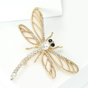 Détail macro d'une élégante broche libellule avec alliage d'or, émail et cristaux