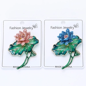 Detailed view of enamel lotus brooches with white pearls and delicate pink crystals