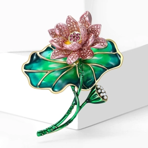 Pink lotus brooch with crystals, green enamel leaves and small white pearls on white background