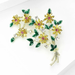 Détail d'une élégante broche bouquet de fleurs avec cristaux jaunes et feuilles vertes