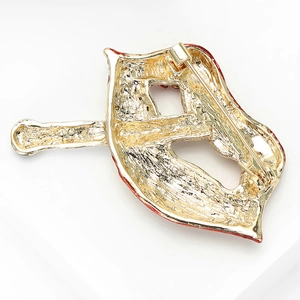 Detailed back view of gold tone lip brooch showing safety pin clasp and metal texture