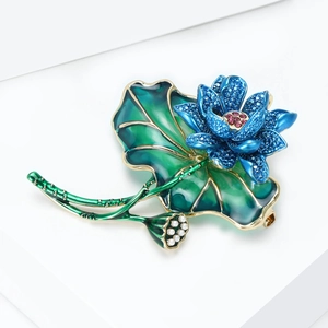 Detailed view of enamel lotus brooch with blue rhinestones and white pearls texture
