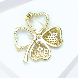 Détails de l'arrière d'une broche trèfle dorée avec cristal et fermeture à épingle de sûreté