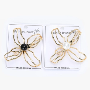 Detail of elegant hollow camellia brooches with gold plating and pearl centerpieces