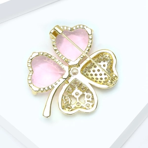 Détail de la broche trèfle avec gemmes cœurs roses et épingle dorée au verso