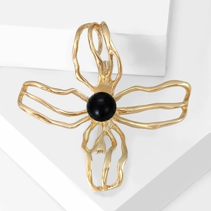 Elegant gold hollow camellia brooch with black pearl center on a white geometric background