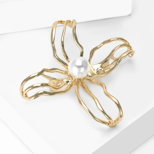 Detail of elegant gold-tone hollow camellia brooch with a central white pearl inlay
