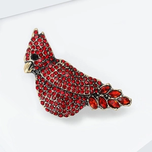 Detailed macro view of cardinal brooch with red rhinestones on a gold alloy base