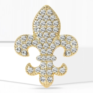 Détail d'une broche fleur de lys vintage avec des strass blancs étincelants et dorés