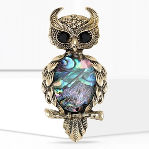 Vintage owl brooch with abalone shell body and black rhinestone eyes in antique gold finish