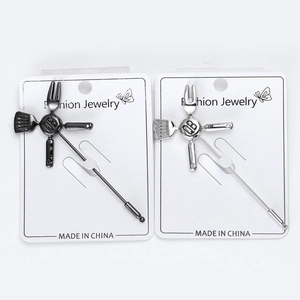 Detail of kitchenware enamel brooches in gun-black and silver on jewelry cards