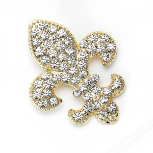 Vue macro détaillée d'une broche fleur de lys vintage avec placage or et cristaux clairs
