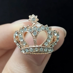 Macro d'une broche couronne en or rose ornée de strass étincelants avec détail d'étoile