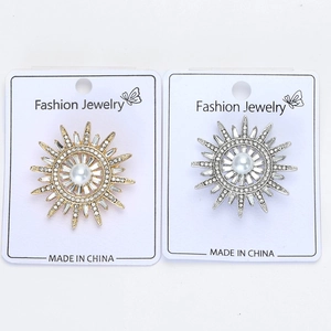 Détail de broches en forme de soleil avec perles et strass brillants sur cartes de support