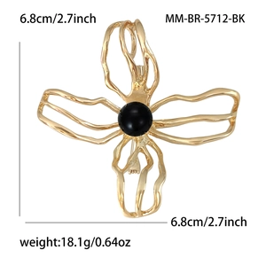Elegant hollow camellia flower brooch with black bead center in a golden finish