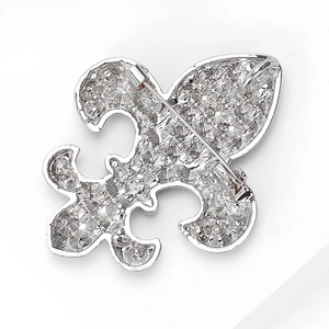 Détail de la broche fleur de lys argentée montrant l'épingle de sûreté et la texture
