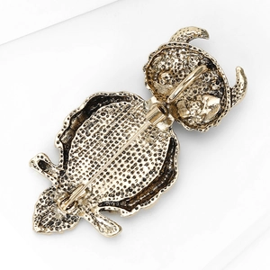 Detailed back view of owl brooch with golden vintage texture and pin closure mechanism
