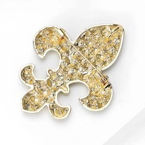 Détail de la broche fleur de lys dorée vintage montrant l'épingle de fermeture arrière