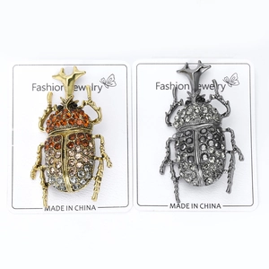 Macro detail of rhinestone beetle brooches on fashion jewelry display cards