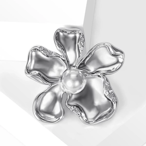 Elegant silver flower brooch with white pearl and sparkling crystals on white background