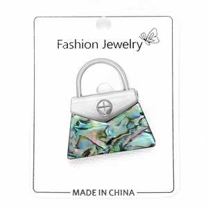 Detailed view of handbag brooch with colorful abalone shell inlay on white card